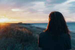 Kvinde kigger på solnedgang og tænker over livet. Livskriser